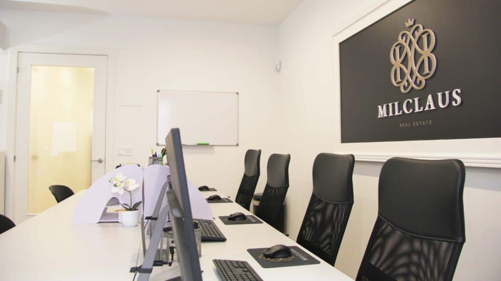 Una oficina en blanco y negro con un letrero en la pared.